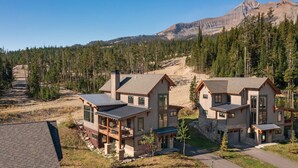 Ein modernes Lodge-Gebäude mit Naturstein-Fassade, großen Fenstern und einer Terrassenfläche.