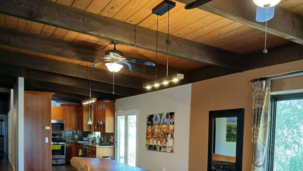 A spacious room with a long wooden table, benches, and a ceiling fan. - Green Valley, Sonoma County Vacation Rental at a Working Winery. (Sebastopol)