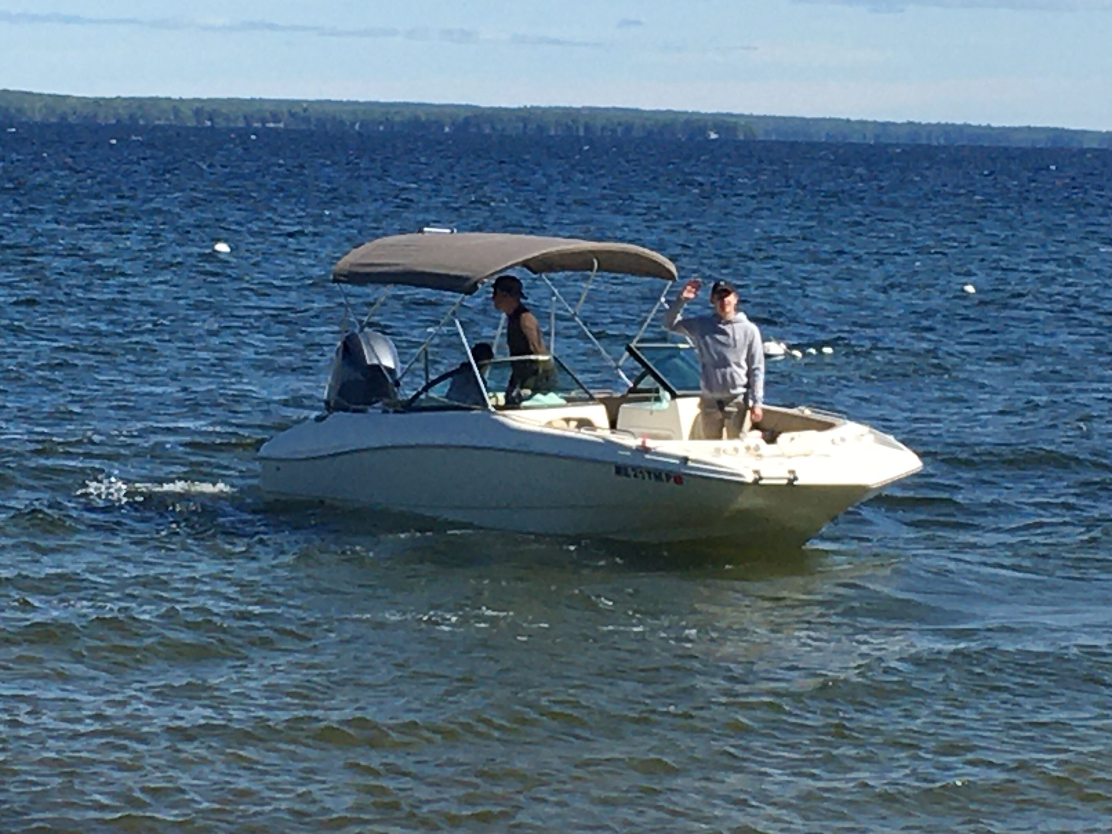 A small motorboat on a body of water with a canopy.