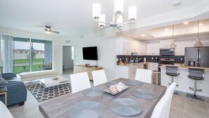 A modern kitchen with white cabinets, a built-in microwave, and a stainless steel refrigerator.