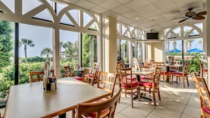 Un restaurant avec de grandes fenêtres, des tables et des chaises en bois.