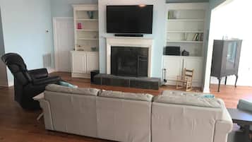 Televisión, chimenea, reproductor de DVD y libros