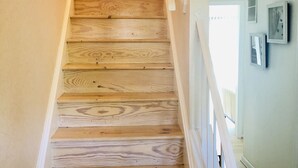 Una escalera de madera con barandillas blancas que conduce a un piso superior.