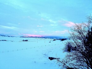 Un paysage enneigé, avec un ciel dégagé et des montagnes lointaines.