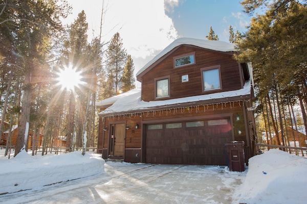 The house is set back on a quiet cul-de-sac surrounded by pine trees
