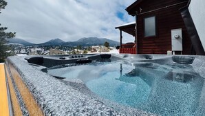 A hot tub with a mountain view, a wooden cabin, and a snowy landscape. - Peak View Retreats Family-friendly,  Rocky Mountain National Park Reg. 3230 (Estes Park)