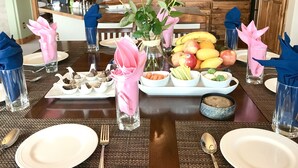 A dining table set with plates, cutlery, and a centerpiece of flowers and fruits. - Peak View Retreats Family-friendly,  Rocky Mountain National Park Reg. 3230 (Estes Park)