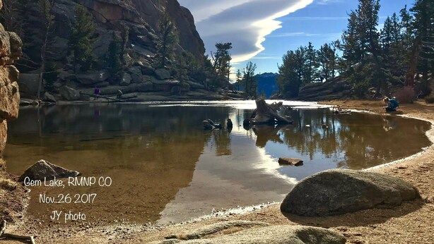 A serene lake with rocky cliffs and trees, surrounded by a natural landscape. - Peak View Retreats Family-friendly,  Rocky Mountain National Park Reg. 3230 (Estes Park)