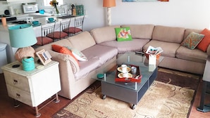 Un salon comprenant un canapé, une table basse et un coin repas avec des chaises et une table.