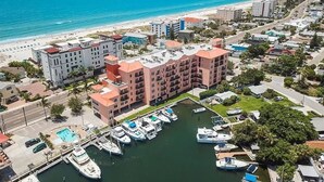 A coastal hotel with multiple buildings, a marina, and a beach view. - Gulf View Condo, Sleeps 6, Pool, Steps to Beach (Madeira Beach)