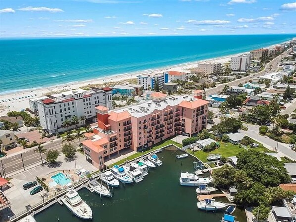 Un hôtel situé sur la côte, composé de plusieurs bâtiments, doté d’un port de plaisance et offrant une vue sur la plage.
