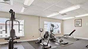A gym with exercise equipment, large windows, and a carpeted floor. - Gulf View Condo, Sleeps 6, Pool, Steps to Beach (Madeira Beach)