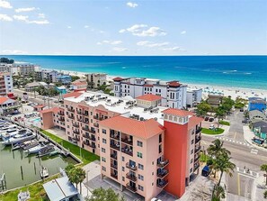 Un hotel frente al mar con varias plantas, un puerto deportivo y vistas a la playa.