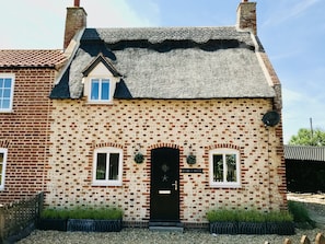A brick building with a black door, two windows, and a sign reading "ROCKET HOUSE".