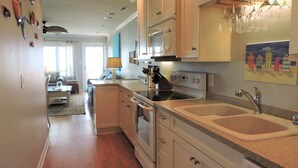 A modern kitchen with a stove, sink, and countertop. - Bright 3BR Beach Home with Deck & Ocean Views (Emerald Isle)