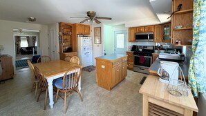 Una cocina amplia con gabinetes de madera, una isla central y electrodomésticos modernos.