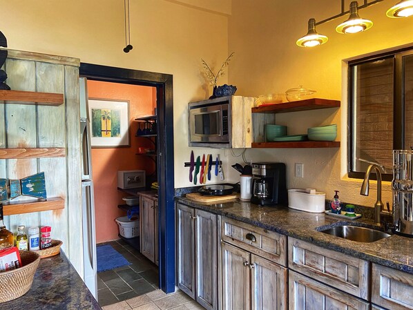 Une cuisine compacte avec des meubles en bois, un four à micro-ondes et une machine à café.