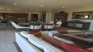 A spacious living area with a sofa set, a coffee table, and a dining table with chairs.