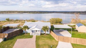 A lakeside property with multiple cabins, a covered patio, and a view of the lake. - Ledgerock Pointe: Private 3/2 Canyon Lake Waterfront + Panoramic Views + Ping Pong + Fenced Yard (Canyon Lake)