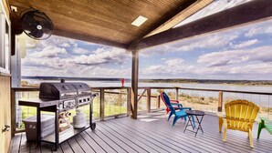 A covered deck with a grill, outdoor chairs, and a view of the water. - Ledgerock Pointe: Private 3/2 Canyon Lake Waterfront + Panoramic Views + Ping Pong + Fenced Yard (Canyon Lake)