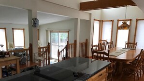 Une cuisine moderne avec un îlot central, une table à manger en bois et des chaises.