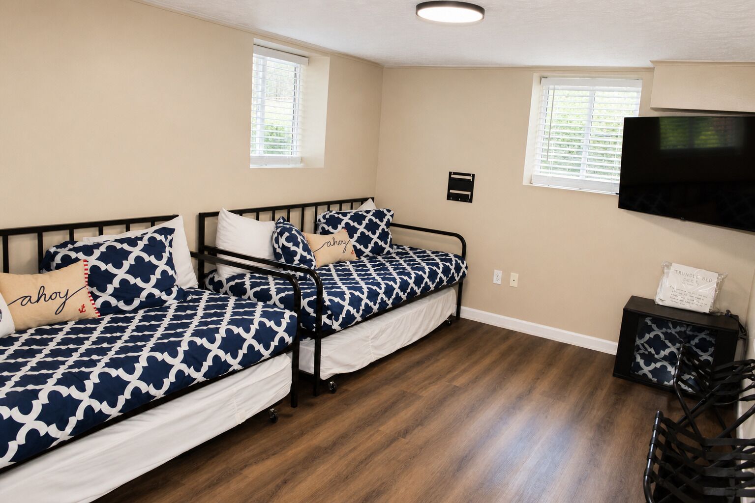 A room with two single beds, a television, and a small table with a chair.