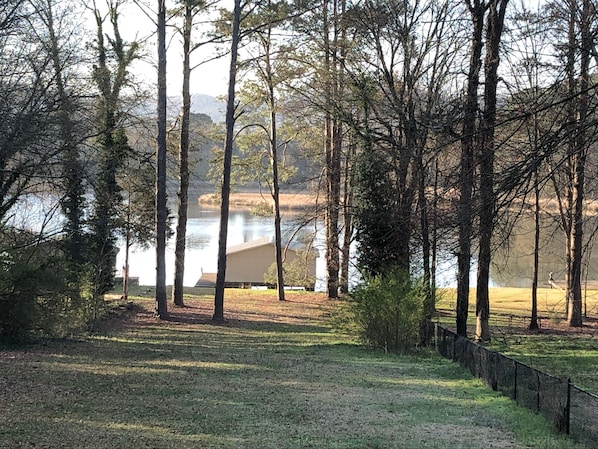 Guests can enjoy serene lake views from a grassy area surrounded by trees.