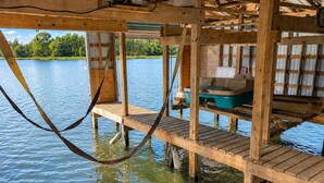 Eine hölzerne Anlegestelle, die sich über das Wasser erstreckt, mit einem Boot und Lagercontainern.
