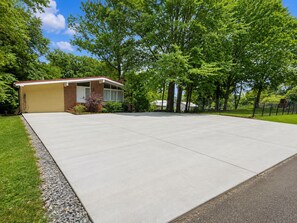 A residential property with a garage, a paved driveway, and a lawn. - Keepin' It Reel: Waterfront, 2-Slip Boathouse, EV, Tankless, Park 5 Boats (Guntersville)