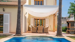 A poolside area with a covered seating area, a pool, and a view of the surrounding landscape. - Villa La Romana with private pool in Mallorca (Crestatx)
