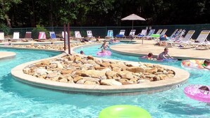 Una piscina con sillones de descanso y flotadores.