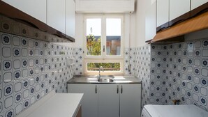 A compact kitchen with white cabinets, a window, and patterned backsplash tiles. - M046 - Marcelli, three-room apartment with terrace 150 meters from the sea (Marcelli)