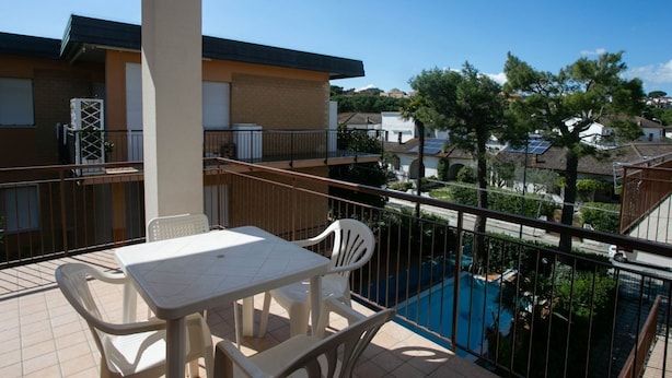 A balcony with a table and chairs, a pool, and a view of surrounding buildings. - M046 - Marcelli, three-room apartment with terrace 150 meters from the sea (Marcelli)