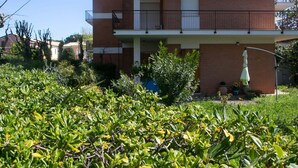 A two-story building with a balcony, surrounded by greenery. - M046 - Marcelli, three-room apartment with terrace 150 meters from the sea (Marcelli)