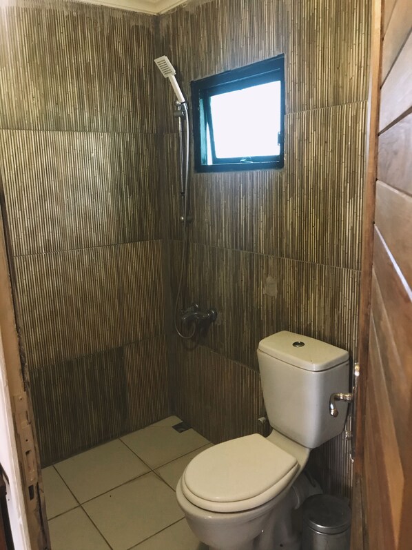 A small bathroom with a shower, a toilet, and a window. - Ceyrek Camping & Bungalows (Kas)