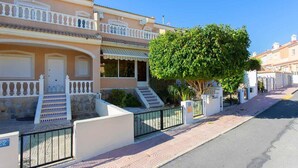 A two-story building with a balcony, a tree in front, and a paved sidewalk. - CH Ronda Doña Pepa (Ciudad Quesada) (Ciudad Quesada)