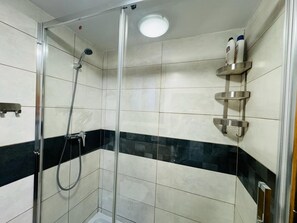 Regadera, secadora de cabello, toallas, papel de baño 