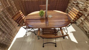 A round wooden table with benches, surrounded by a woven bamboo fence, on a tiled floor. - 4 mint to beach and 20 mint to las Ramblas plaza catalunya Barcelona  (San Adrián del Besós)