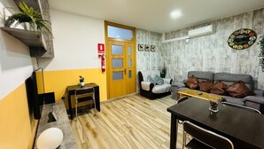 A living room with a wooden floor, a sofa, a coffee table, a TV, and a fireplace. - 4 mint to beach and 20 mint to las Ramblas plaza catalunya Barcelona  (San Adrián del Besós)