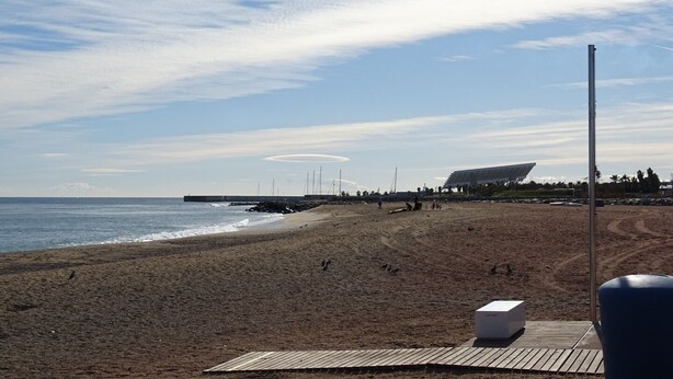 A beach with a wooden walkway, a white structure, and a modern building in the background. - 4 mint to beach and 20 mint to las Ramblas plaza catalunya Barcelona  (San Adrián del Besós)