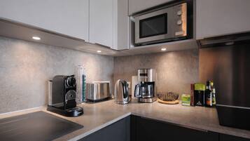A modern kitchen with a microwave, toaster, coffee maker, and various appliances.