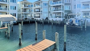 A waterfront property with multiple buildings, docks, and a boat. - Chincoteague Getaway on the Bay - Water Front,Pool ,IN TOWN ,LINENS & TOWELS (Chincoteague)