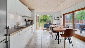 A modern kitchen with a large dining area, wooden ceiling, and large windows. - Nice home in Stubbekøbing with WiFi (Stubbekøbing)