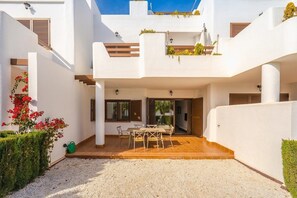 Ein modernes Haus mit Terrasse, Essbereich und überdachter Außenfläche.