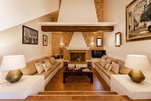A living room with two sofas, a coffee table, and a fireplace. - Villa with terrace and BBQ equipped with all amenities (Sant Francesc de Formentera)
