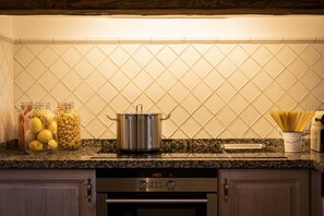 A kitchen with granite countertops, stainless steel appliances, and a tiled backsplash.