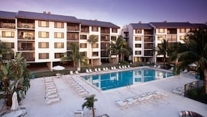A hotel with multiple floors, a central swimming pool, and outdoor seating areas.