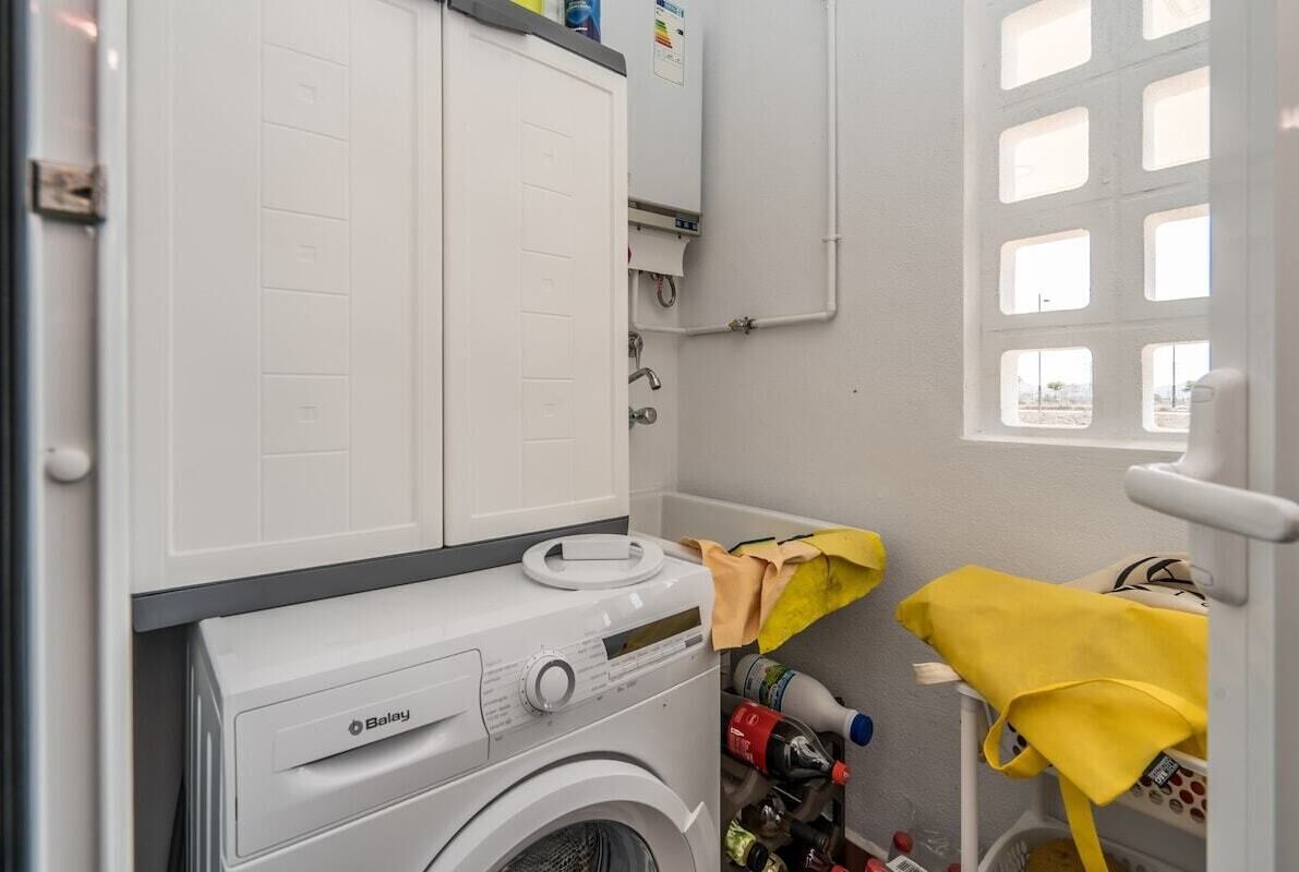 Une buanderie équipée d’un lave-linge à chargement frontal, d’un sèche-linge et d’une pièce annexe avec une fenêtre.