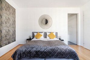 Une chambre à coucher avec un lit, un miroir rond et un mur à texture.