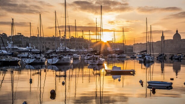 A marina at sunset with multiple boats docked, calm water, and a historic building in the background. - Cosy Maltese Townhouse, Roof Terrace and Views (Senglea)